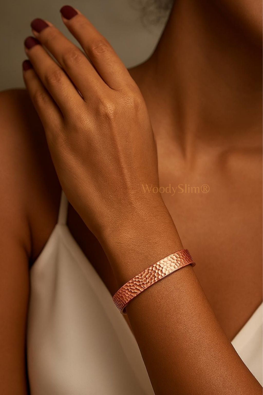 Bracelet en cuivre tressé WoodySlim porté au poignet d'une femme, ambiance chaude et élégante.