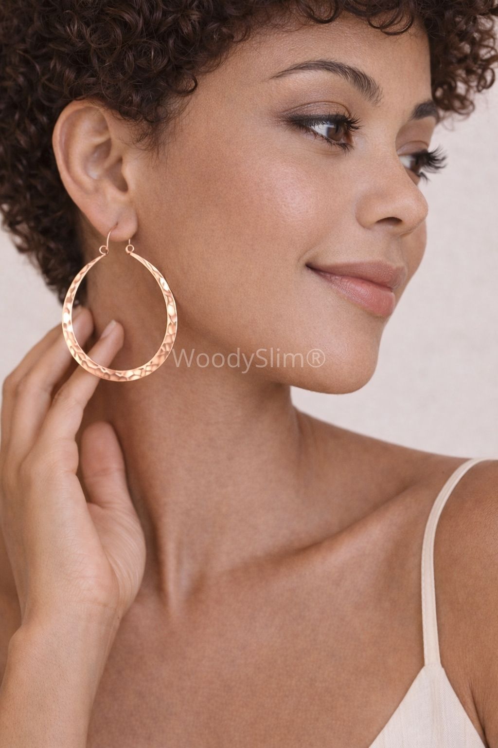 Boucles d’oreilles créoles en cuivre martelé portées par une femme, style naturel et lumineux, bijou féminin WoodySlim.