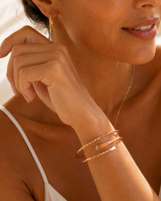 Femme méditerranéenne bronzée portant un bracelet en cuivre WoodySlim dans une ambiance lumineuse et haut de gamme.