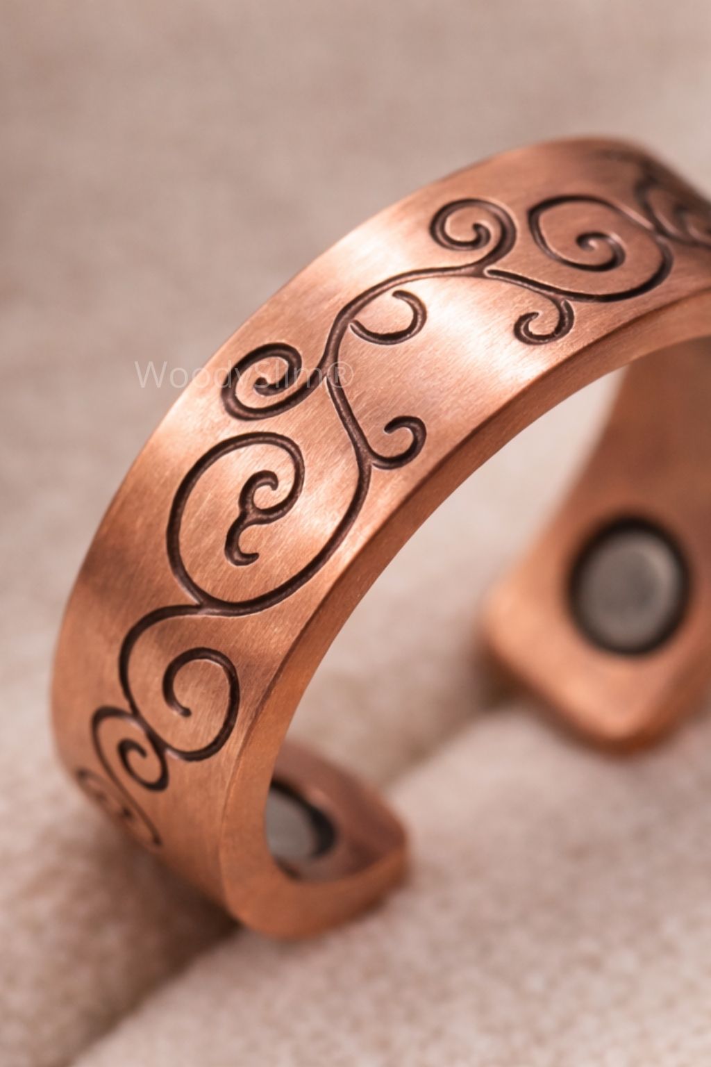 Bague en cuivre gravée motifs arabesques présentée sur un support blanc, largeur de l’anneau et détails visibles, bijou WoodySlim.