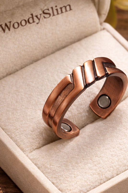 Bague ouverte en cuivre magnétique WoodySlim® posée dans un écrin beige avec logo WoodySlim, vue d’ensemble sur fond bois naturel, bijou bien-être au design épuré