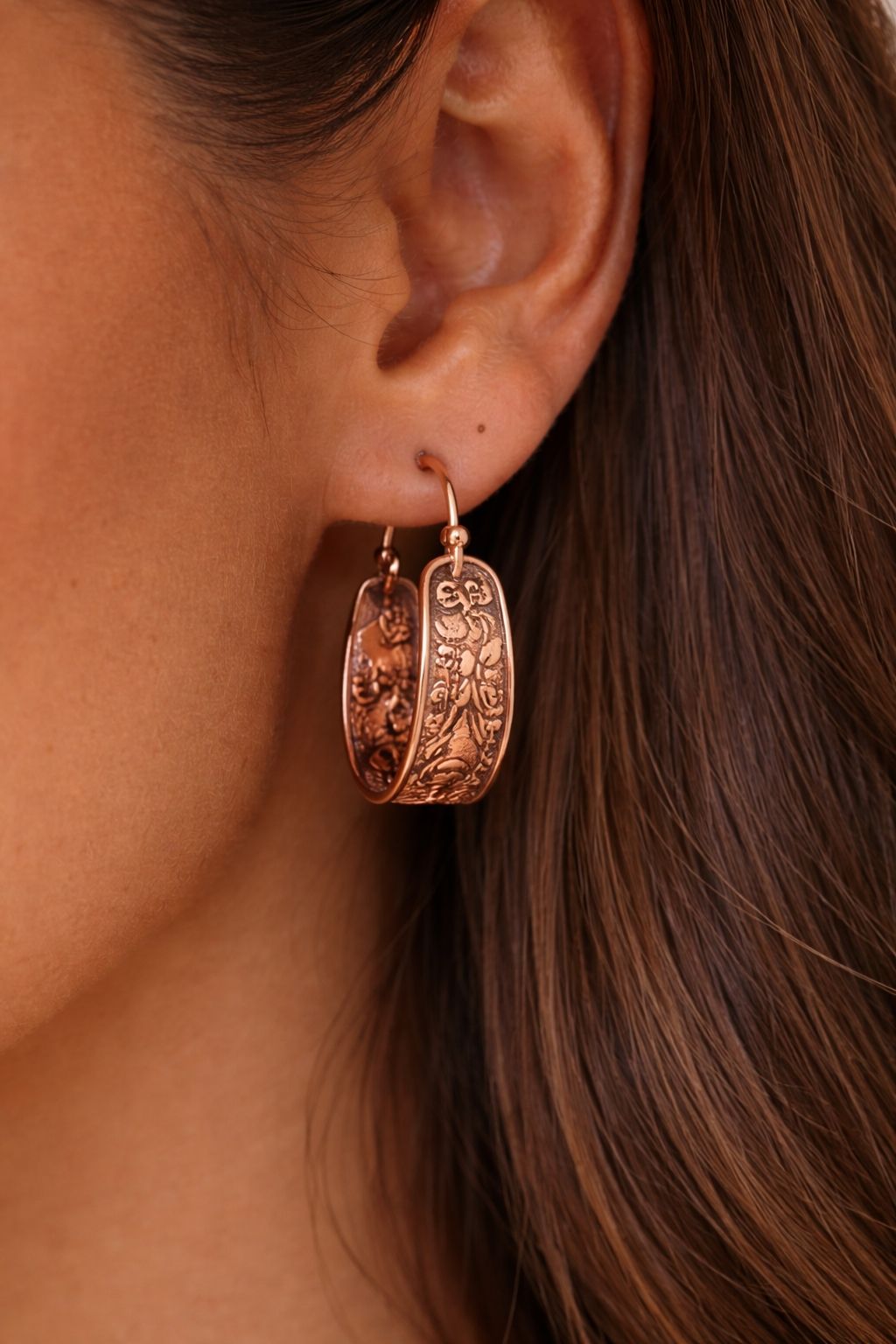 Boucles d’oreilles en cuivre gravé portées à l’oreille d’une femme, finition rosée, bijou élégant et intemporel WoodySlim.