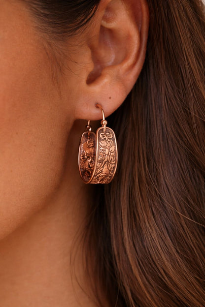 Boucles d’oreilles en cuivre gravé portées à l’oreille d’une femme, finition rosée, bijou élégant et intemporel WoodySlim.