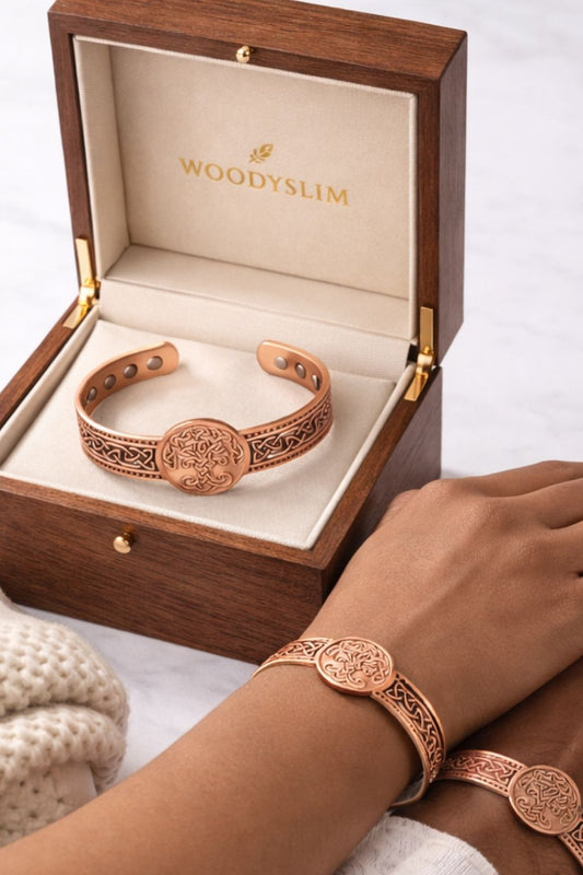Bracelet en cuivre WoodySlim® dans un écrin en bois noble à l’intérieur crème et logo doré. Deux poignets côte à côte portent le même modèle, en symbole de lien fort et de style partagé.