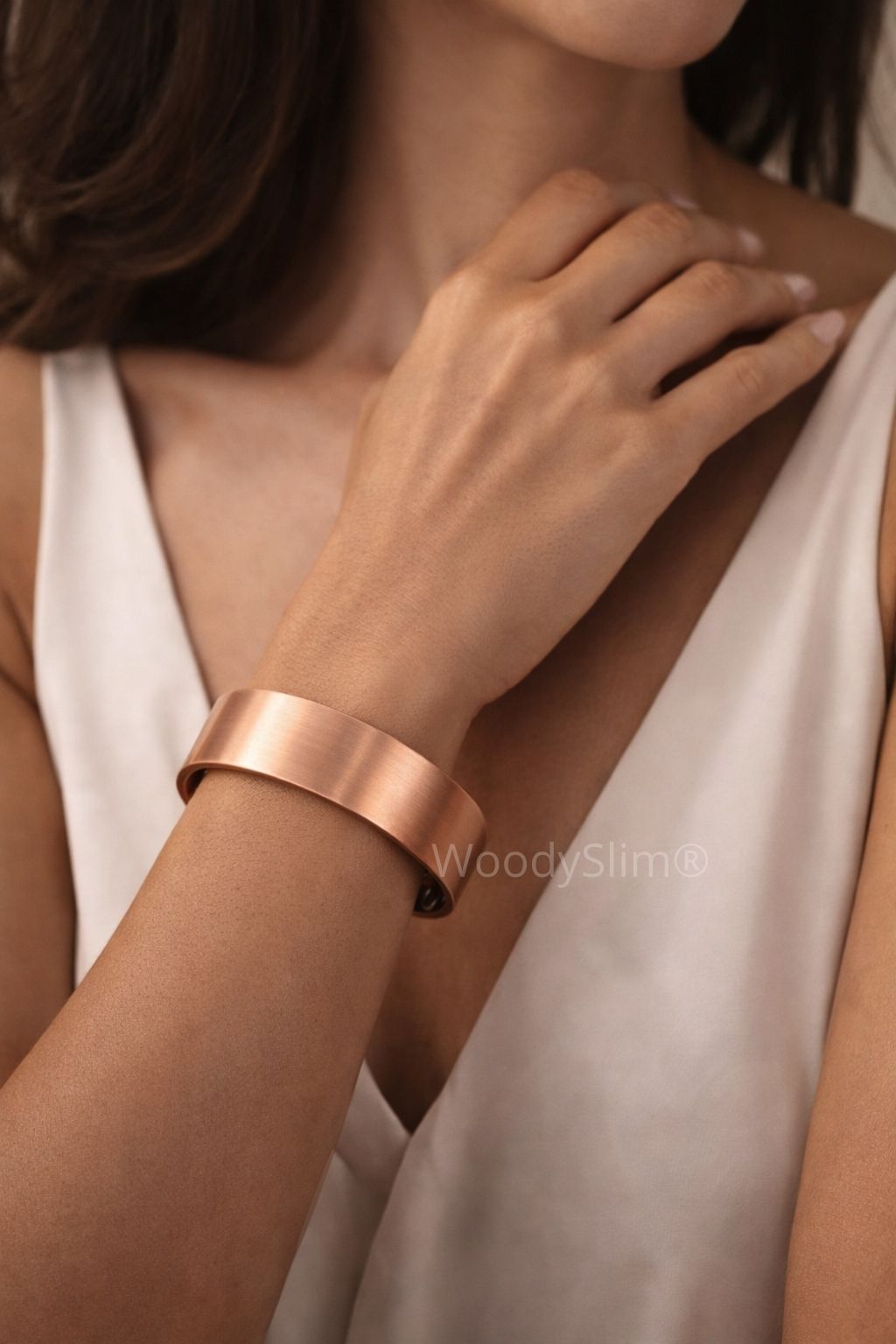 Bracelet manchette en cuivre mat WoodySlim porté par une femme élégante à la peau hâlée, bijou minimaliste et intemporel au poignet.