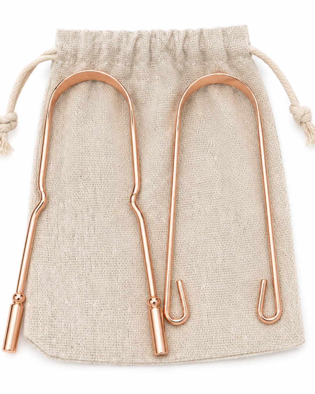 Deux gratte-langue en cuivre avec pochette en tissu naturel, accessoire d’hygiène quotidienne inspiré des rituels ayurvédiques.