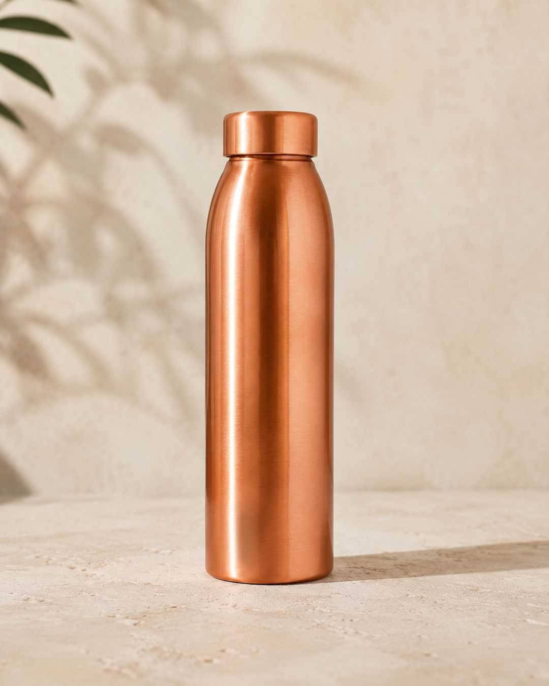 Gourde en cuivre 1L WoodySlim® au design lisse et premium, posée seule dans une ambiance beige épurée et haut de gamme.