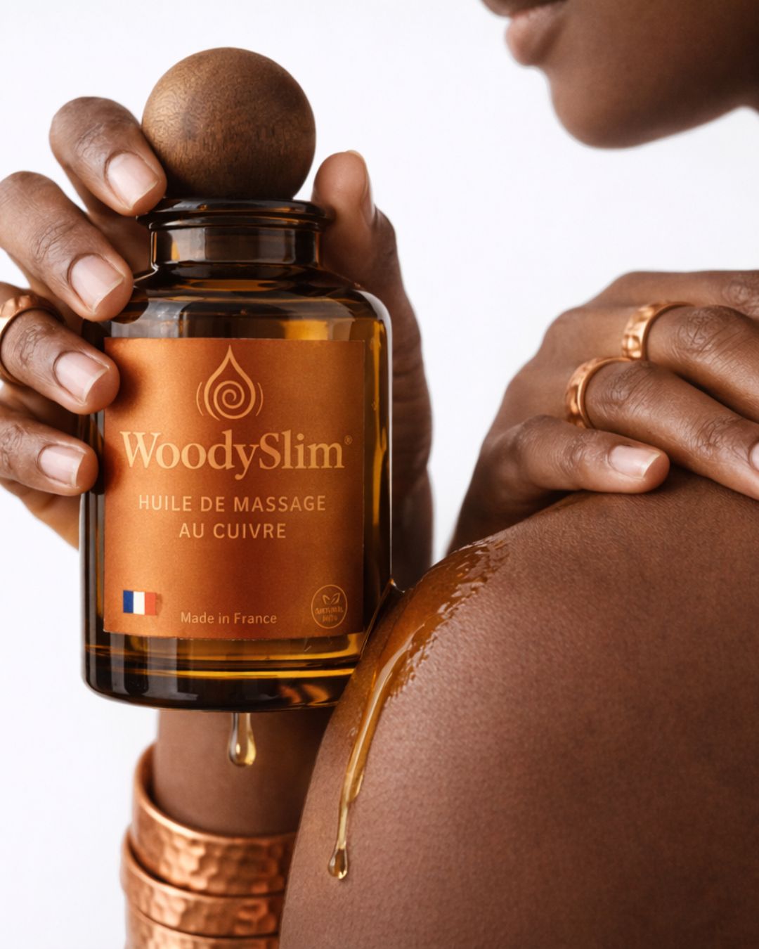 Huile de massage au cuivre WoodySlim appliquée sur l’épaule pour un rituel corporel sensoriel.