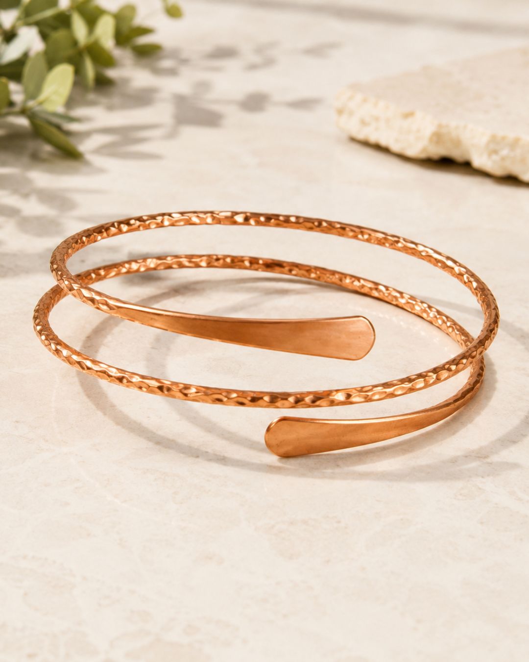 Gros plan sur un bracelet en cuivre martelé WoodySlim porté au poignet dans une lumière naturelle chaude.